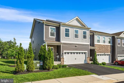 a view of a big house with a big yard and large trees