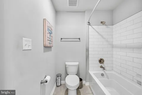 a white toilet sitting next to a bath tub