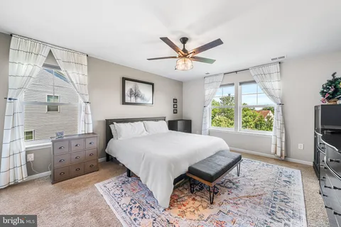 a spacious bedroom with a bed and a flat screen tv