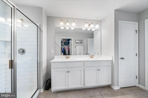 a bathroom with a double vanity sink and a mirror