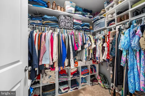 a view of walk in closet with clothes