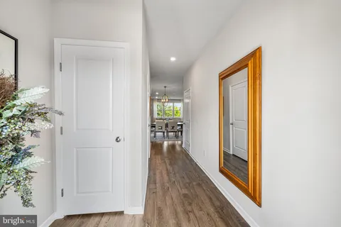 a view of a hallway with wooden floor and a dining room