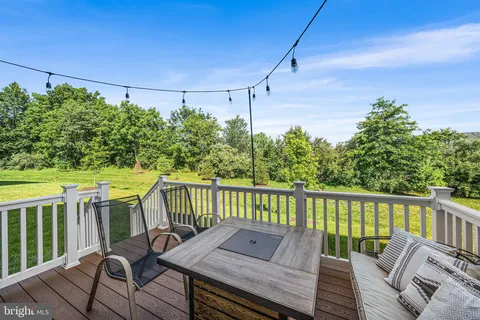 a balcony with wooden floor and outdoor seating