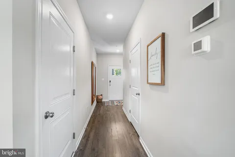 a view of a hallway with wooden floor and staircase