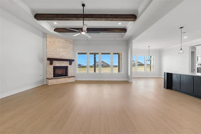 a view of empty room with fireplace and wooden floor