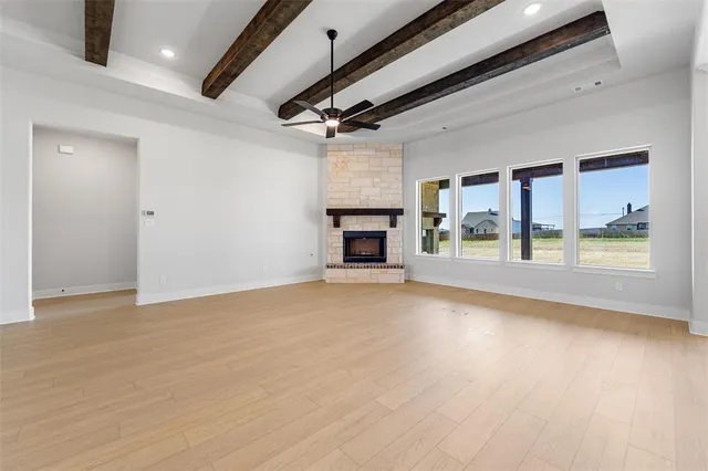 a view of empty room with wooden floor and fireplace