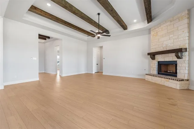 a view of a livingroom with a ceiling fan wooden floor and window