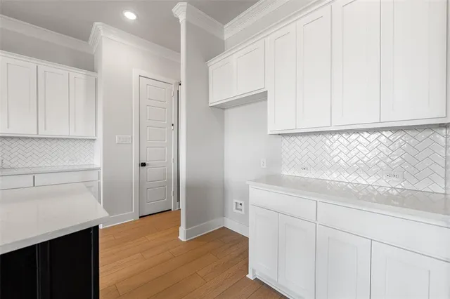 a kitchen with granite countertop white cabinets and white appliances