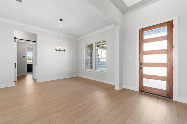 an empty room with wooden floor ceiling fan and windows