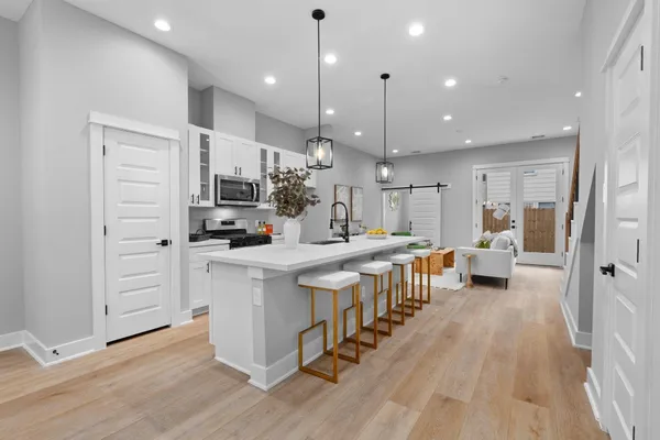 an open kitchen with white cabinets and stainless steel appliances