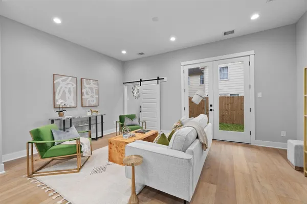 a living room with furniture and a wooden floor