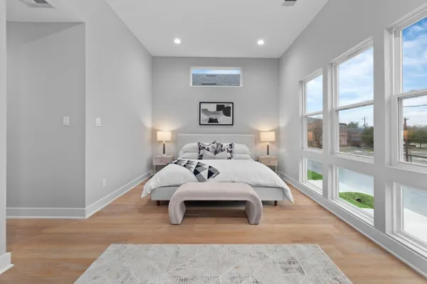 a bedroom with a bed and a large window