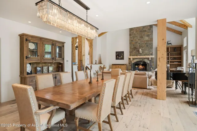 a dining room with furniture a fireplace and chandelier