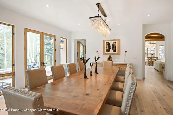a view of a dining room with furniture a chandelier and wooden floor