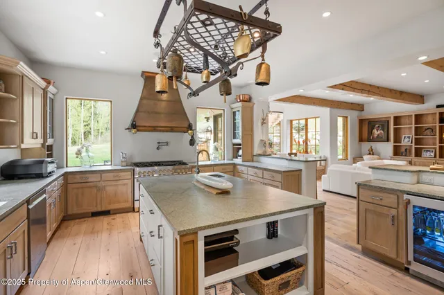 a kitchen with a stove a sink dishwasher and a refrigerator with wooden floor