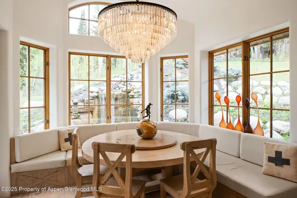 a dining room with furniture a chandelier and wooden floor