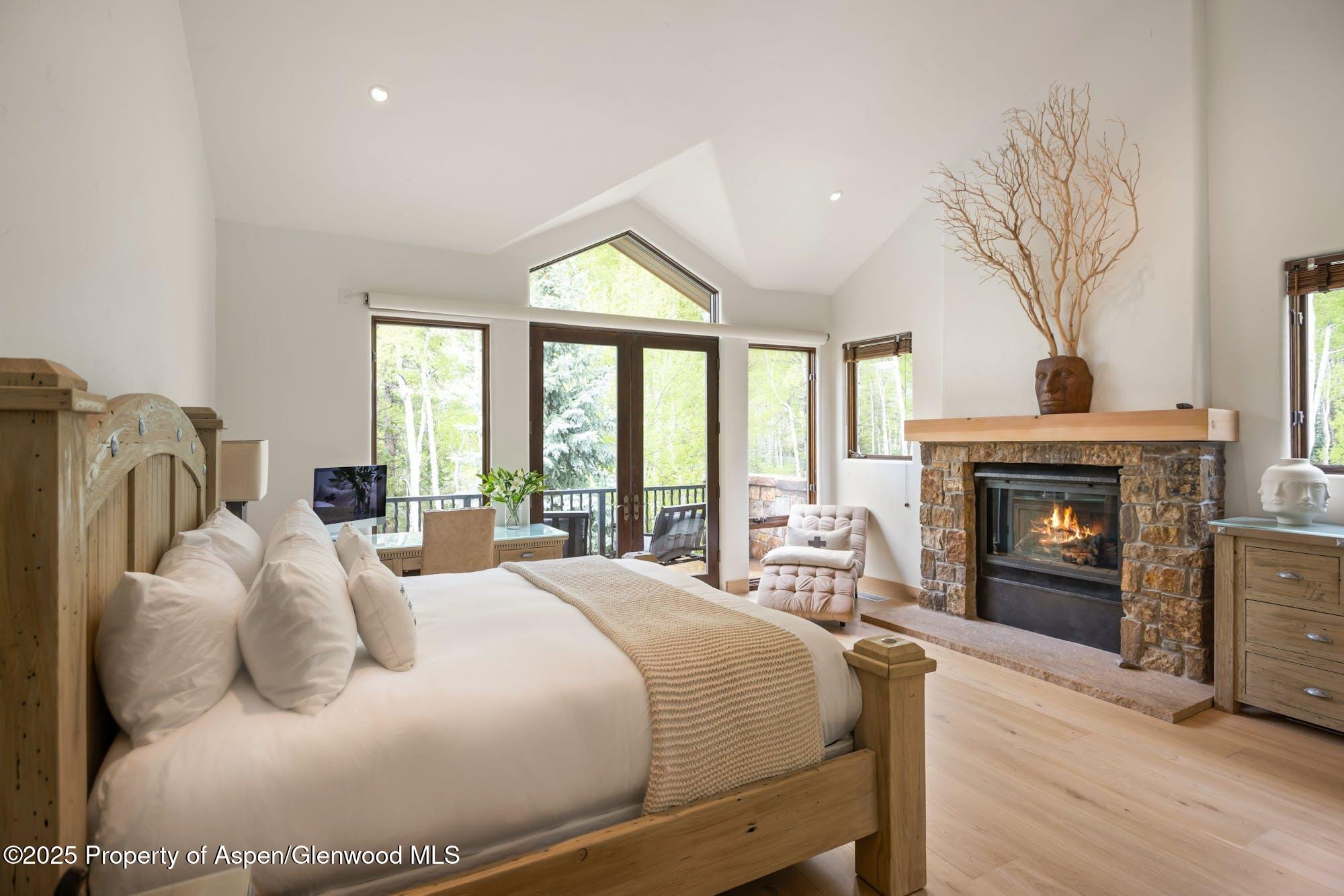 350 Spruce Ridge Lane Snowmass Village, CO 81615 - Photo 27 of 38 a bedroom with a bed and a fireplace