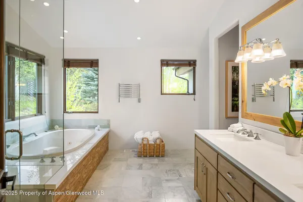 a bathroom with a tub sink and mirror