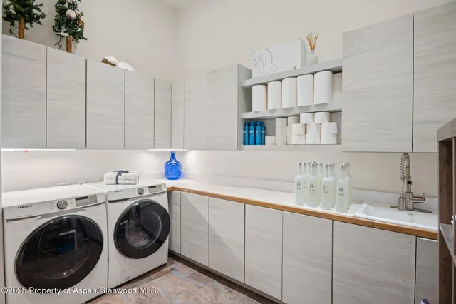 a utility room with sink dryer and washer
