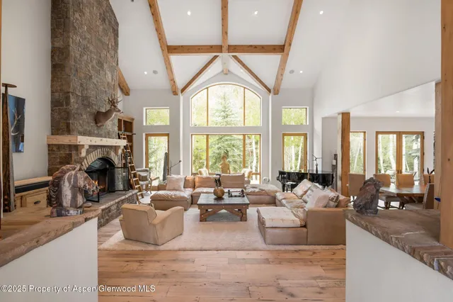 a living room with fireplace furniture and a large window