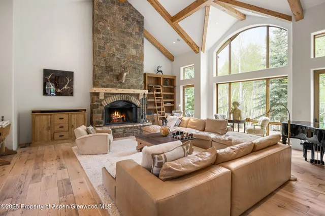 a living room with furniture fireplace and a large window