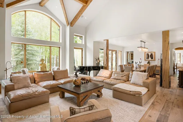 a living room with furniture a large window and a chandelier