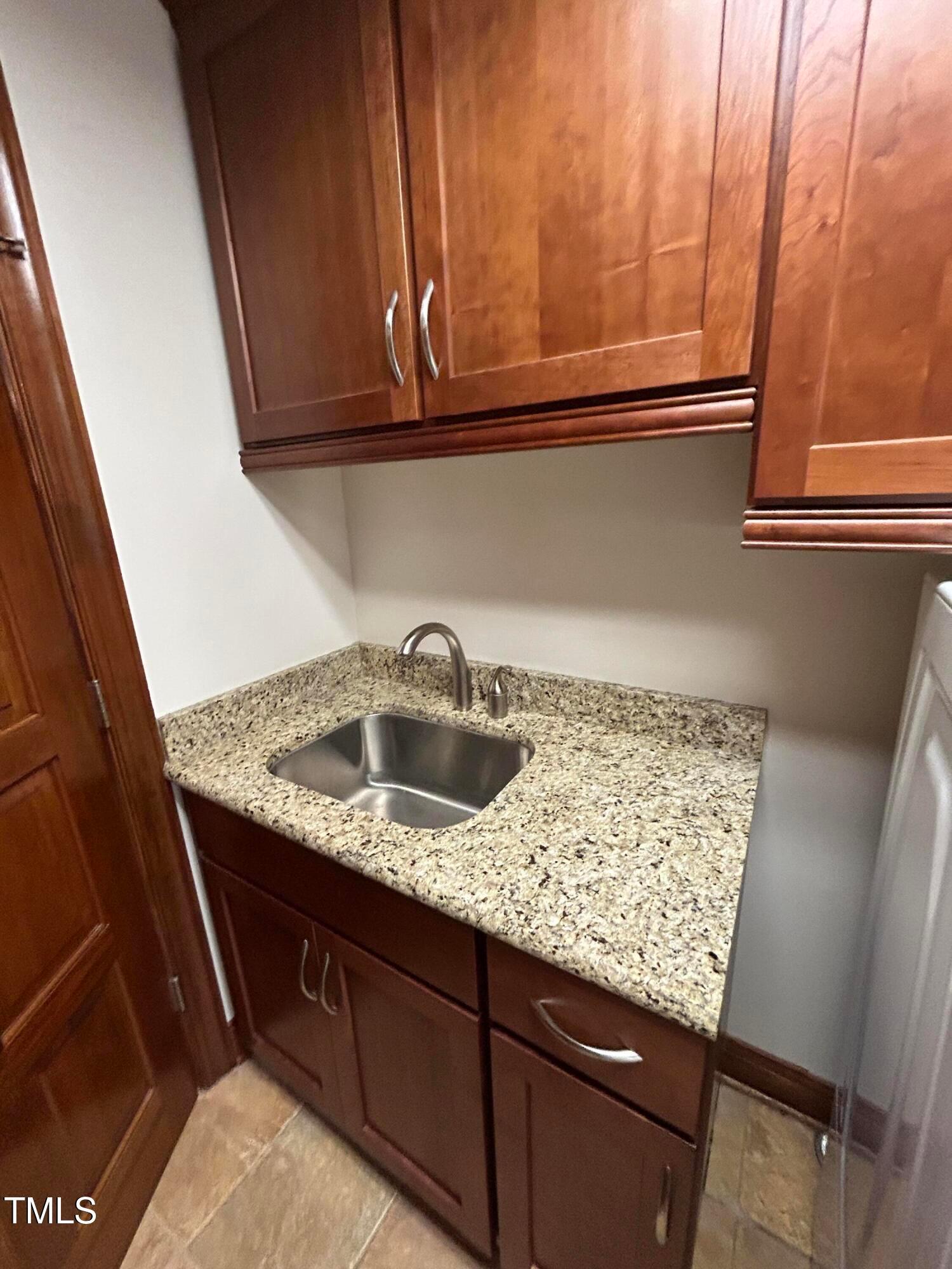106 Springbrook Place Cary, NC 27518 - Photo 23 of 49 a kitchen with granite countertop sink and cabinets
