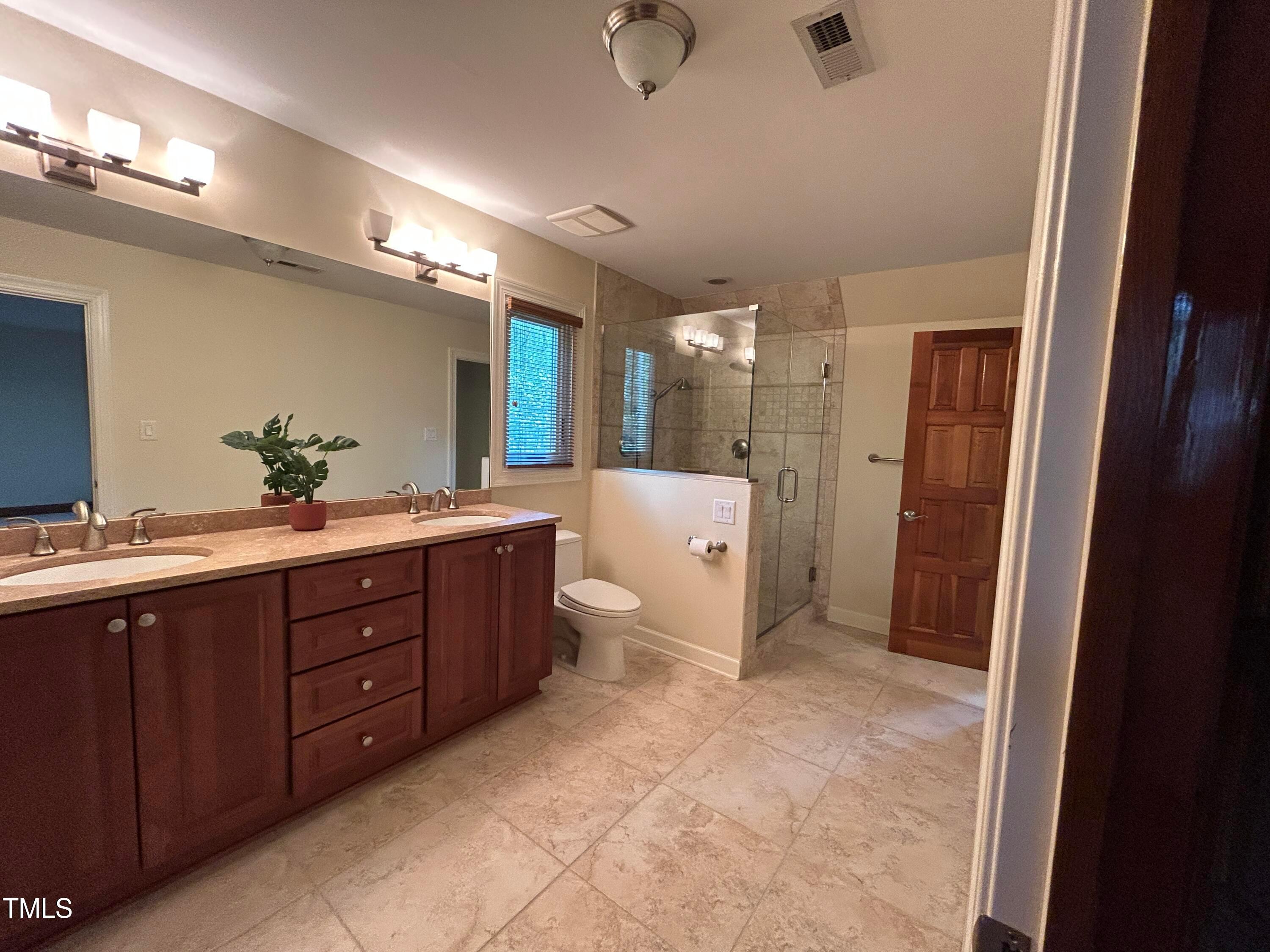 106 Springbrook Place Cary, NC 27518 - Photo 35 of 49 a spacious bathroom with a double vanity sink a large mirror and a shower