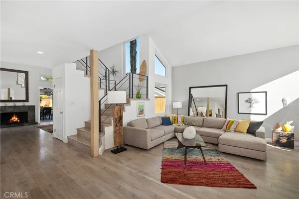a living room with furniture a fireplace and wooden floor
