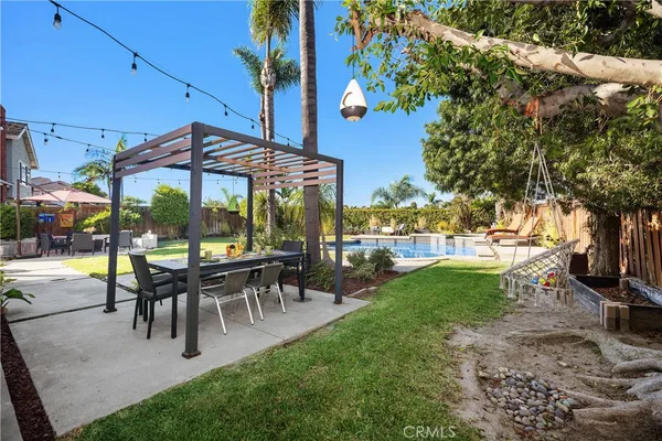 a view of a patio with table and chairs potted plants and palm tree