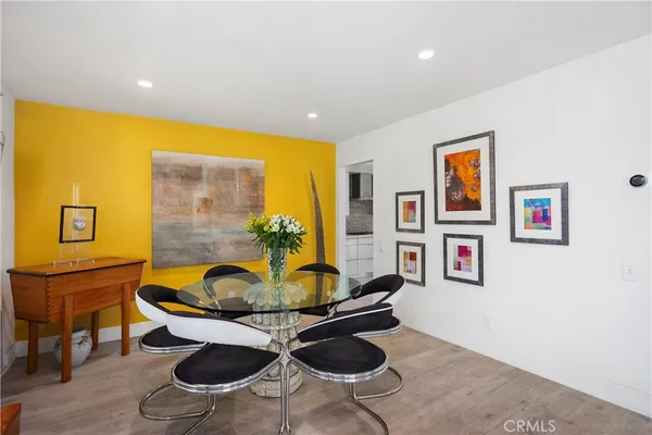 a living room with furniture a rug and wall paintings