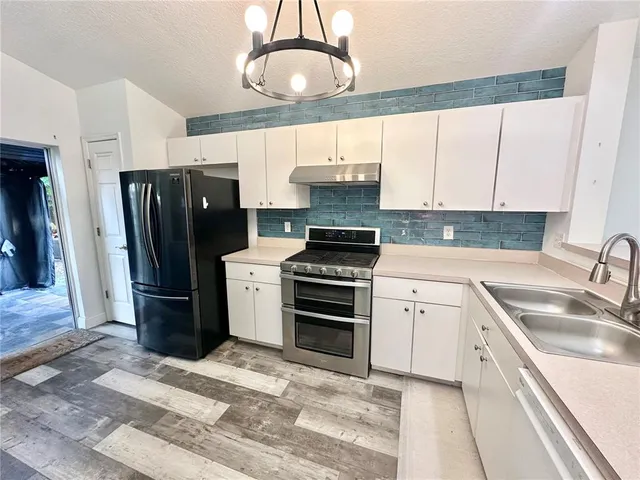 a kitchen with a sink stainless steel appliances and cabinets