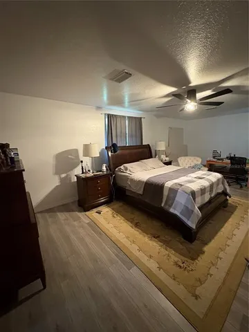 a bedroom with a bed and ceiling fan