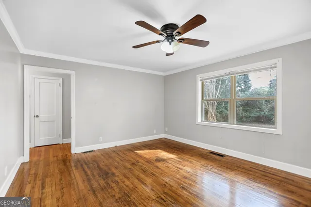 a view of a big room with wooden floor and windows