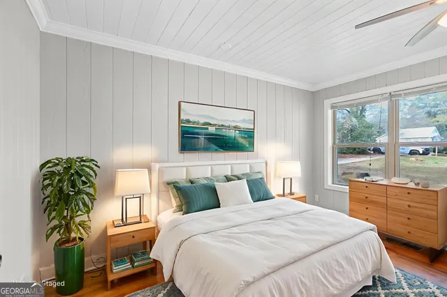 a bedroom with a bed table chair and a window