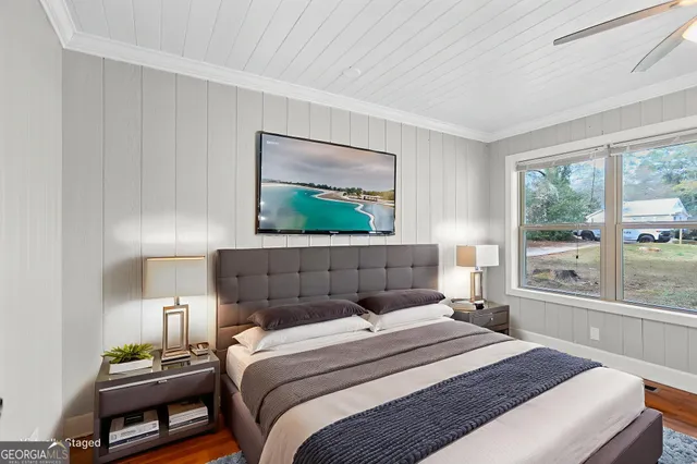 a bedroom with a bed a lamp and a large window