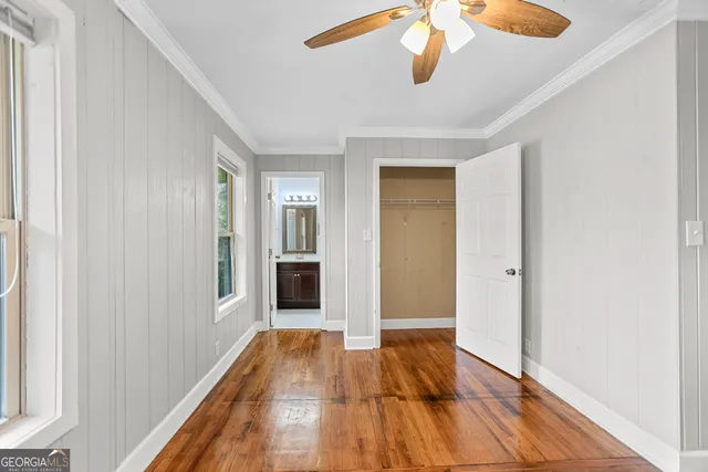 a view of a hallway with wooden floor and chandelier