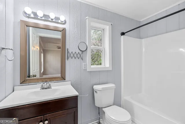 a bathroom with a sink vanity mirror and toilet