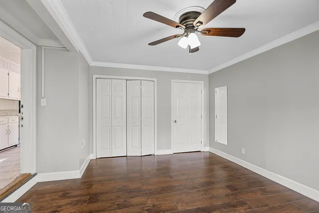 a view of a livingroom with a ceiling fan wooden floor and window