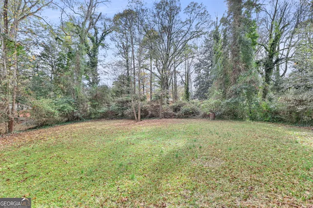 a view of a field with trees in the background