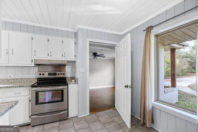 a kitchen with white cabinets and appliances