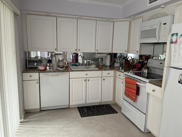 247 Capri F Delray Beach, FL 33484 - Photo 2 of 14 a kitchen with white cabinets and white appliances