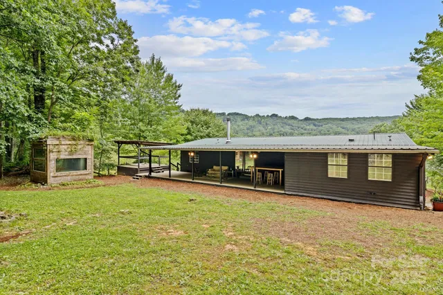 a front view of house with yard and trees in the background