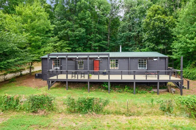 a aerial view of a house with swimming pool lawn chairs and a yard