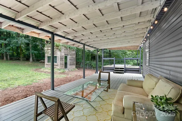 a view of a patio with table and chairs potted plants with wooden floor and fence