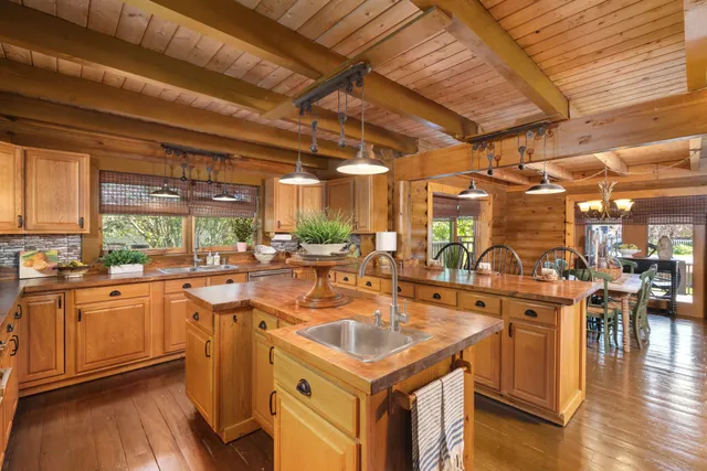 a kitchen with stainless steel appliances granite countertop a refrigerator a stove and a wooden floors