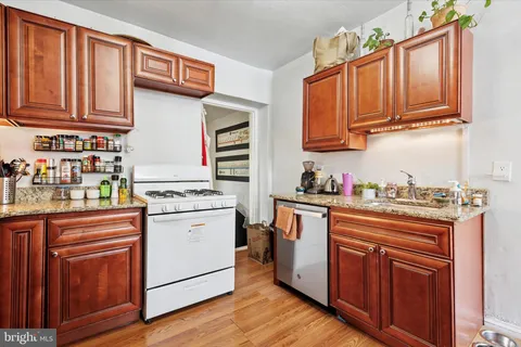 a living room with stainless steel appliances granite countertop a refrigerator and a cabinets