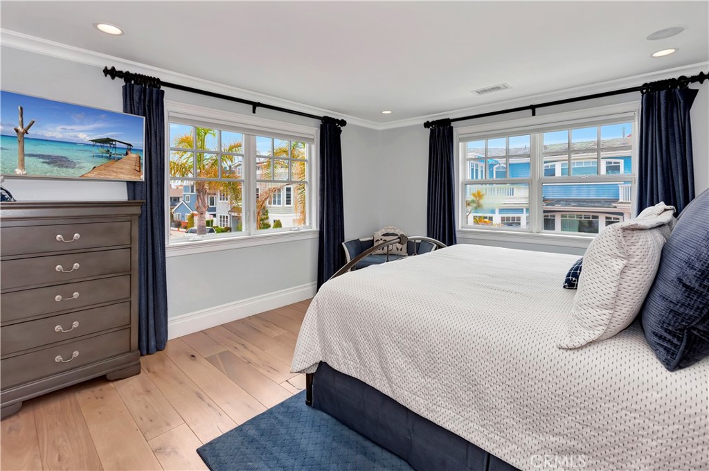 1102 West Oceanfront Newport Beach, CA 92661 - Photo 23 of 32 a large bed sitting in a bedroom next to a window