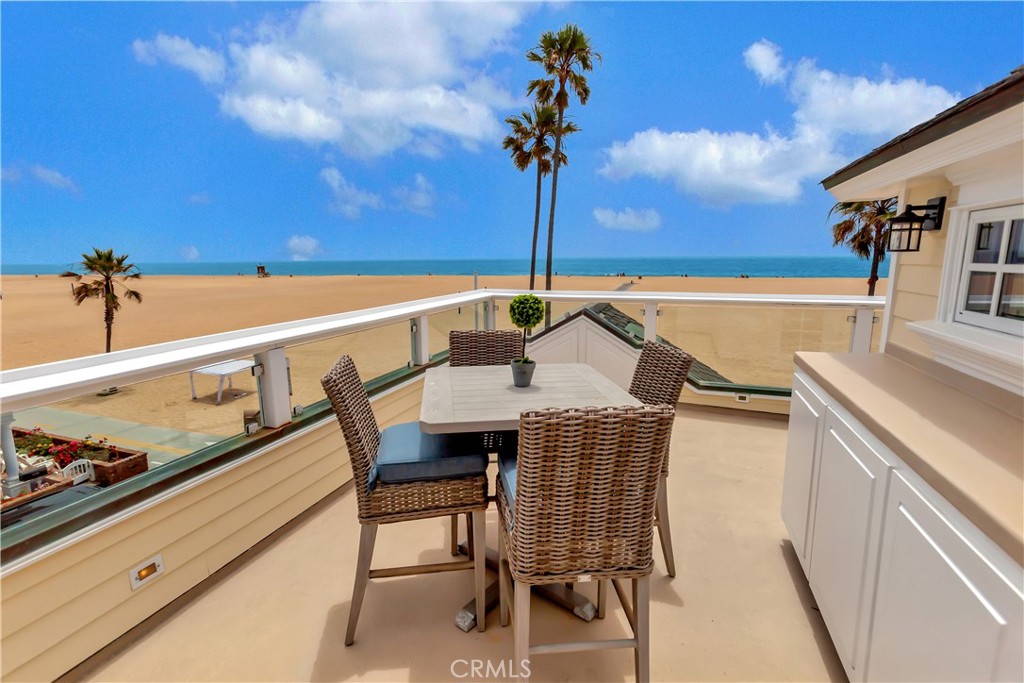 1102 West Oceanfront Newport Beach, CA 92661 - Photo 29 of 32 a roof deck with a table and chairs with wooden floor
