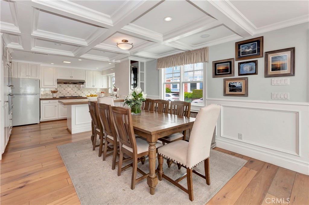 1102 West Oceanfront Newport Beach, CA 92661 - Photo 9 of 32 a dining room with stainless steel appliances kitchen island granite countertop furniture and wooden floor